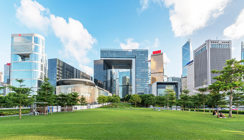 Modern skyscrapers and green urban park, representing government digital service validation