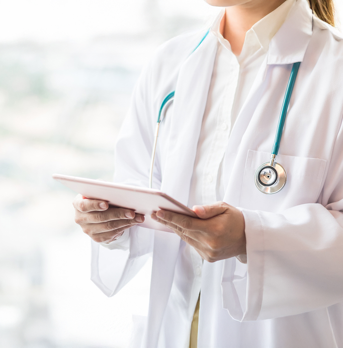 A doctor wearing a white coat, holding a tablet, conveying a sense of professional healthcare.